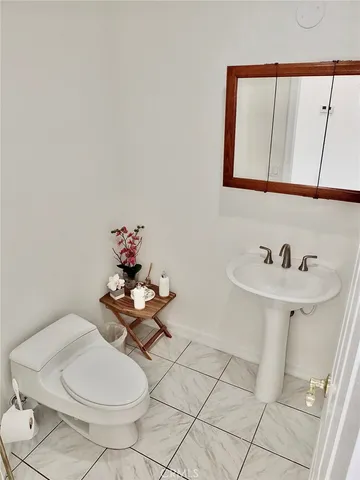 a view of a white vase with flowers on a table