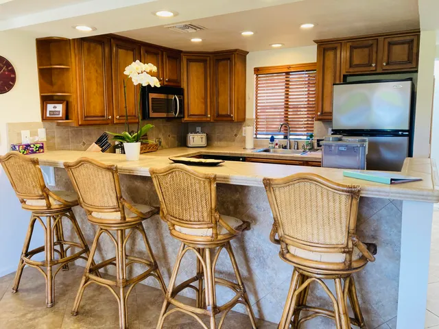a kitchen with kitchen island granite countertop wooden cabinets a stove top oven a sink and dishwasher