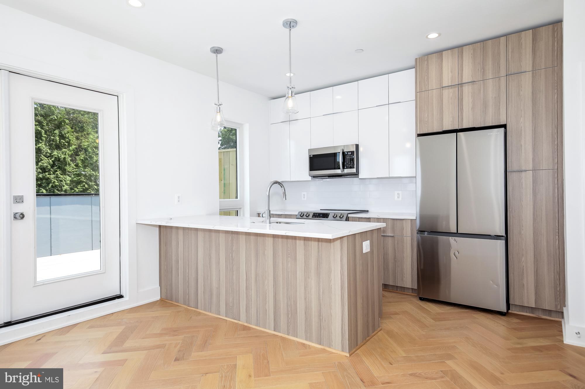 a kitchen with kitchen island a refrigerator sink and microwave