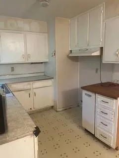 a kitchen with granite countertop white cabinets and a sink