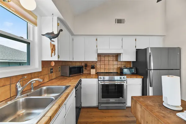 a kitchen with stainless steel appliances a stove a sink and a refrigerator