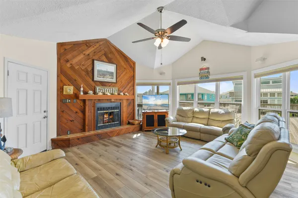 a living room with furniture a fireplace and a large window