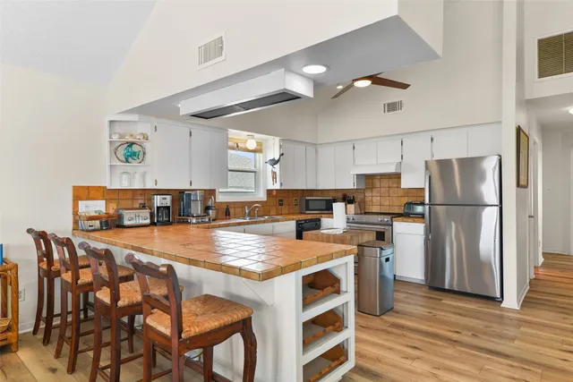 a kitchen with stainless steel appliances a table chairs and a refrigerator