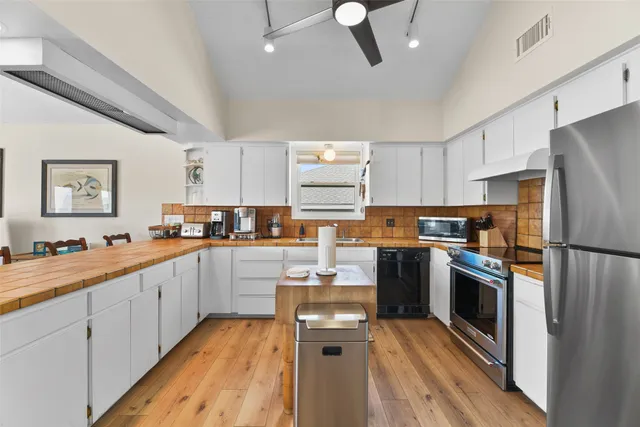 a kitchen with cabinets a sink and stainless steel appliances