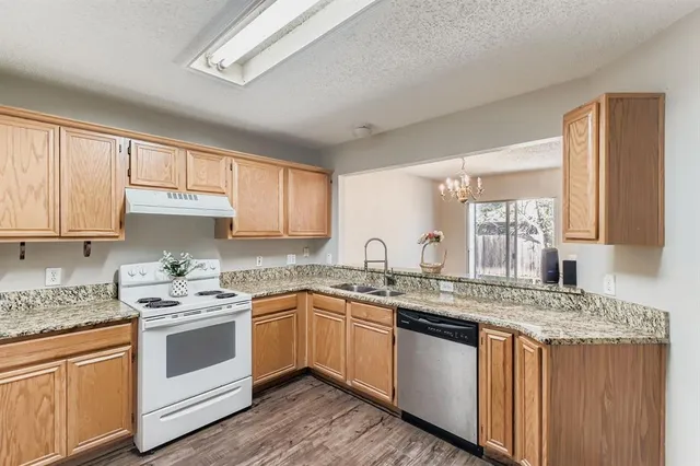 a kitchen with stainless steel appliances granite countertop a sink stove and cabinets