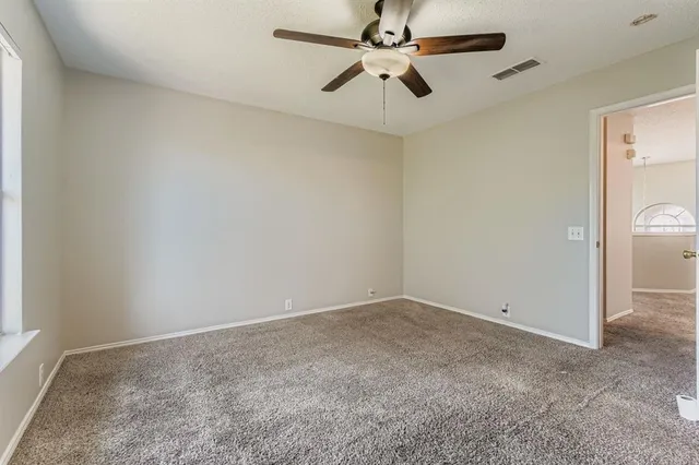 an empty room with a fan and a fan