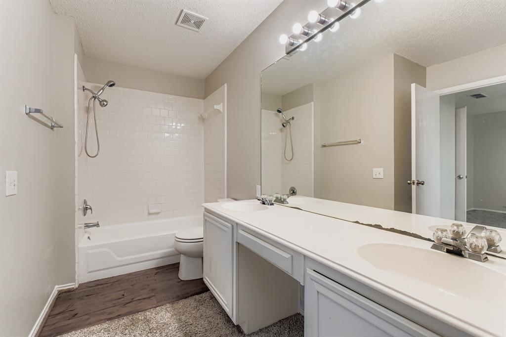 8532 Tallahassee Lane Fort Worth, TX 76123 - Photo 19 of 29 a bathroom with a sink a toilet and shower