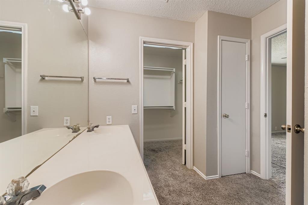 8532 Tallahassee Lane Fort Worth, TX 76123 - Photo 20 of 29 a en suite bathroom with a sink and mirror
