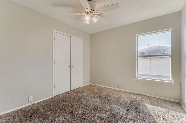 an empty room with windows and closet