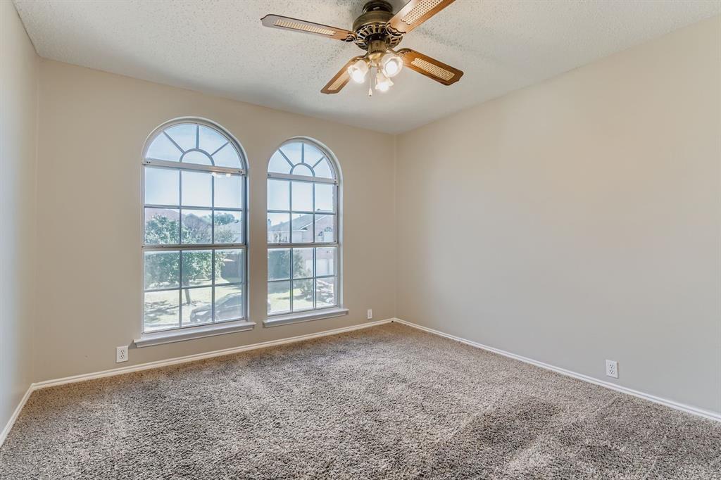 8532 Tallahassee Lane Fort Worth, TX 76123 - Photo 23 of 29 an empty room with windows and ceiling fan