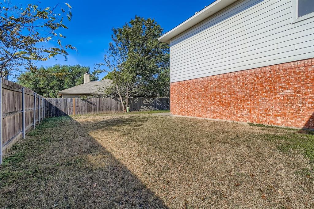 8532 Tallahassee Lane Fort Worth, TX 76123 - Photo 28 of 29 a view of a backyard with large trees and wooden fence