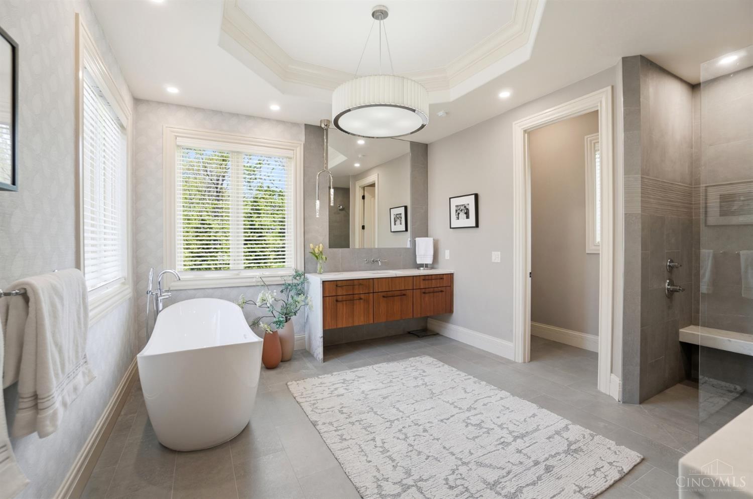 4535 Drake Road Cincinnati, OH 45243 - Photo 35 of 96 The spa-like primary bathroom has been thoughtfully updated with heated floors, dual vanities, a soaking tub, and a walk-in shower.