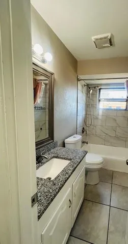 a bathroom with a granite countertop sink and mirror