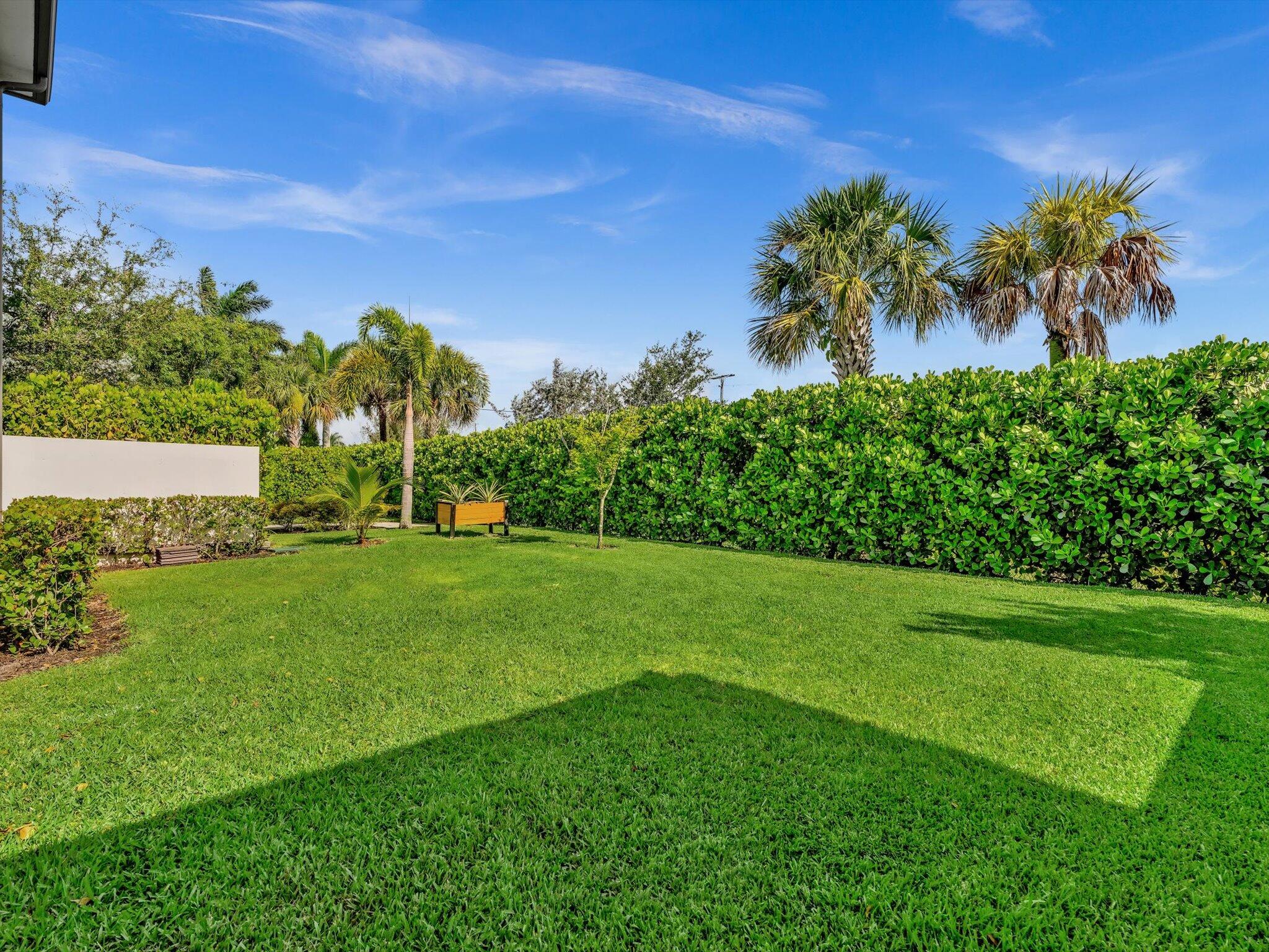 4708 Saddle Ranch Road Lake Worth, FL 33467 - Photo 31 of 45 a view of a garden with a building in the background
