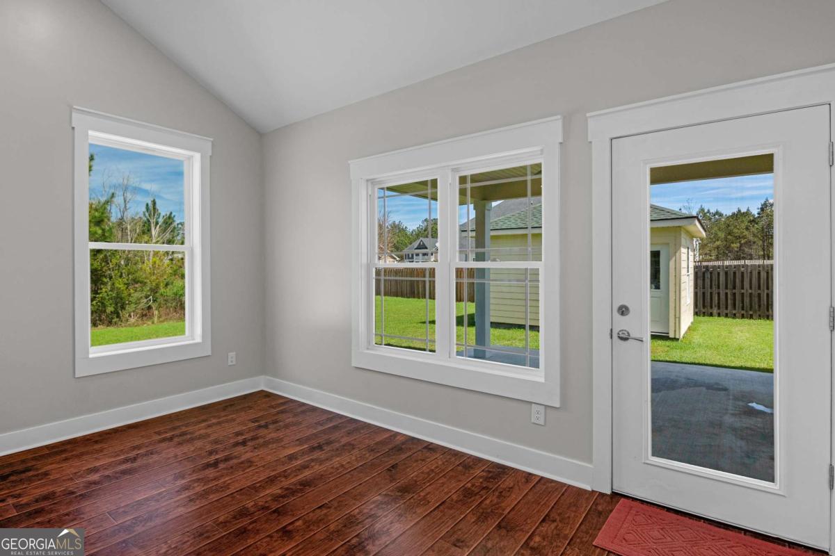 328 Windsor Road Guyton, GA 31312 - Photo 12 of 39 an empty room with wooden floor and windows