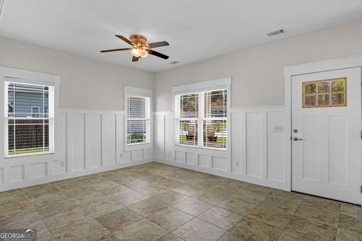 328 Windsor Road Guyton, GA 31312 - Photo 5 of 39 a view of an empty room with a window and wooden floor