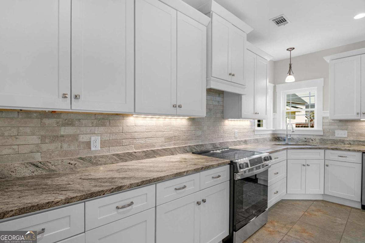 328 Windsor Road Guyton, GA 31312 - Photo 10 of 39 a kitchen with granite countertop white cabinets and white stainless steel appliances with a sink