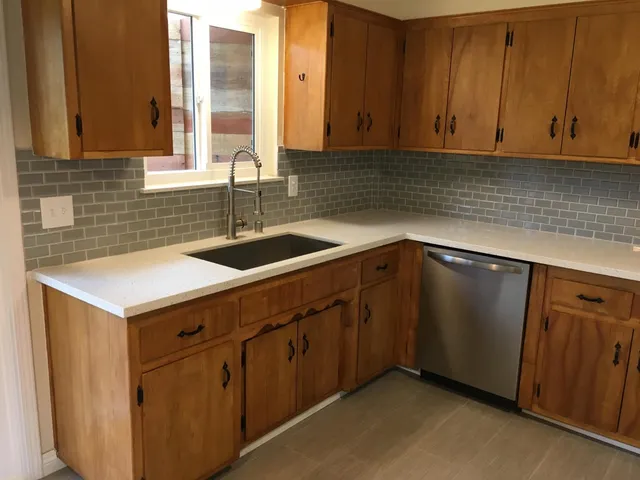 a kitchen with a sink cabinets and window