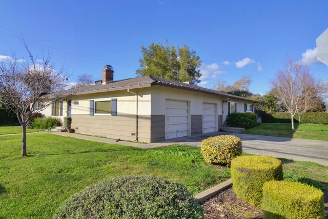 a view of a house with backyard and a tree