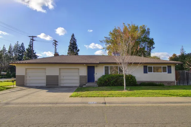a view of a house with a patio and a yard