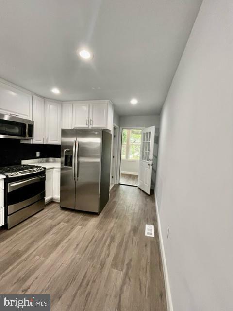 1812 North Smallwood Street Baltimore, MD 21216 - Photo 17 of 21 a kitchen with wooden floors and stainless steel appliances