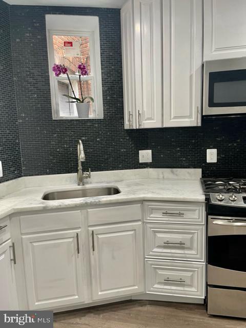 1812 North Smallwood Street Baltimore, MD 21216 - Photo 21 of 21 a kitchen with white cabinets and appliances