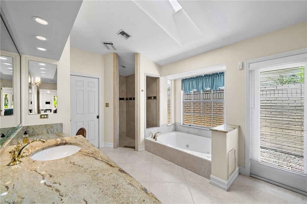 547 Devils Lane Naples, FL 34103 - Photo 10 of 13 a spacious bathroom with a tub sink and mirror