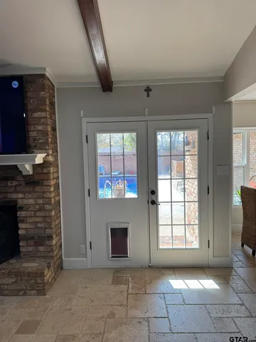 a view of an empty room with a fireplace and a window