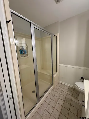 a bathroom with a glass door shower and toilet