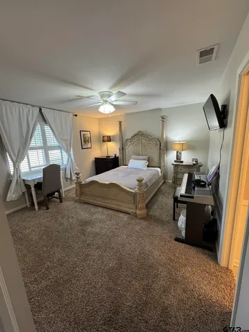 a bedroom with furniture and a flat screen tv