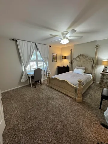 a spacious bedroom with a bed and a chandelier