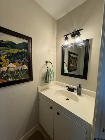 a bathroom with a sink mirror and vanity