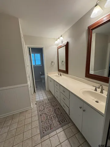 a spacious bathroom with a double vanity sink and a mirror
