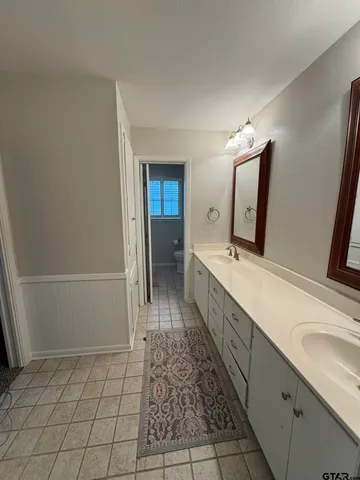 a spacious bathroom with a double vanity sink and a mirror