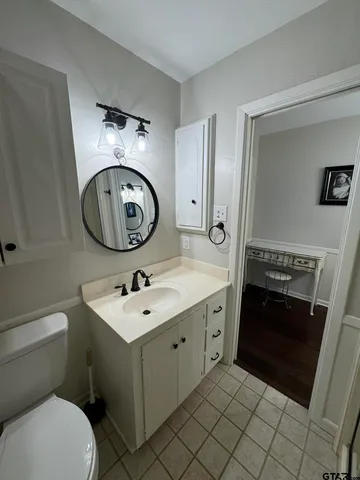 a bathroom with a toilet sink and mirror