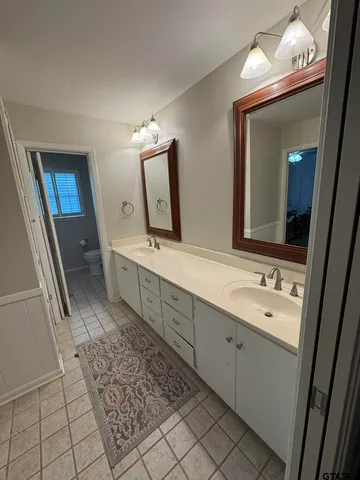 a spacious bathroom with a double vanity sink and a mirror