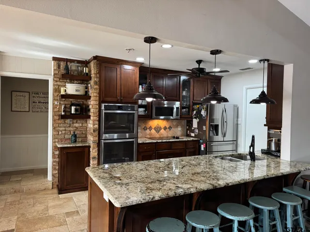 a kitchen with kitchen island a counter space and stainless steel appliances