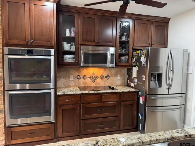 a kitchen with granite countertop stainless steel appliances and wooden cabinets