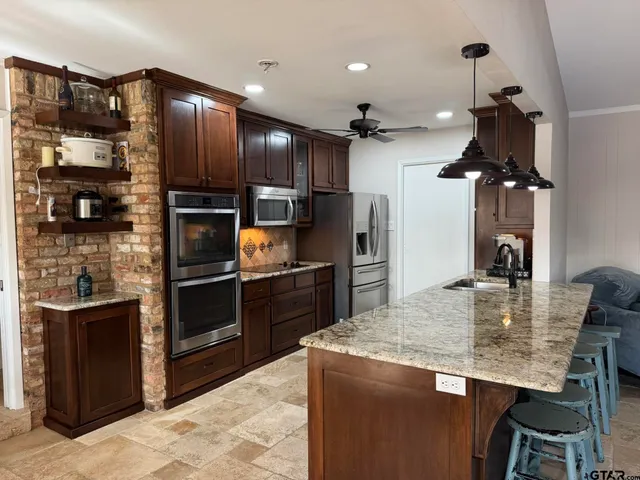 a kitchen with refrigerator a stove and chairs