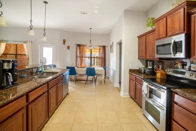 a kitchen with stainless steel appliances granite countertop a sink counter space cabinets and a large window