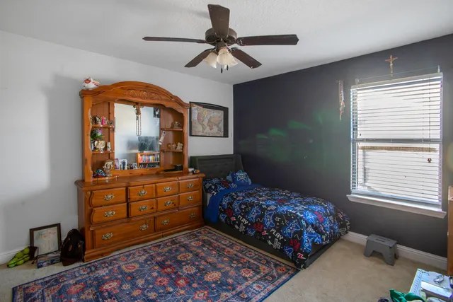 a bedroom with a bed and a mirror on dresser