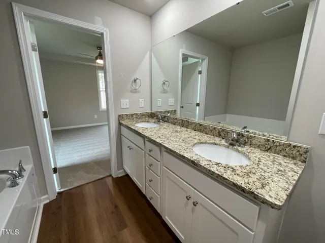 a bathroom with a granite countertop sink and a mirror