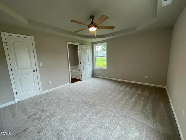 an empty room with a ceiling fan and windows