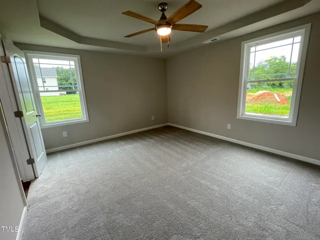 an empty room with closet and windows