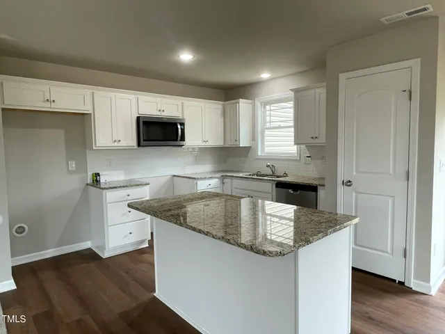 a kitchen with granite countertop a sink and a stove top oven