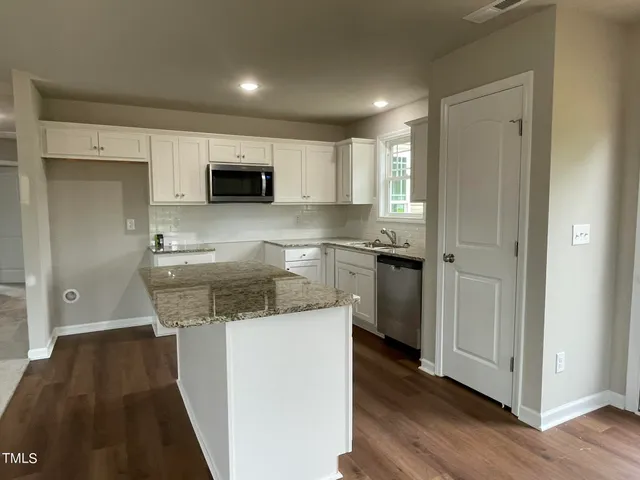 a kitchen with stainless steel appliances granite countertop a sink and cabinets