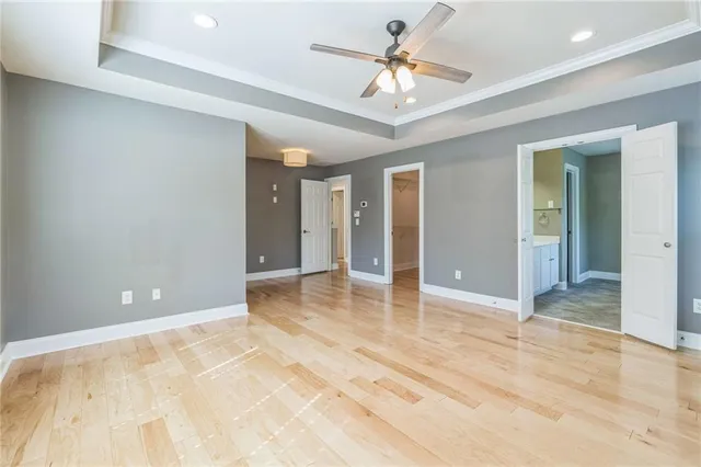 a view of an empty room and chandelier fan
