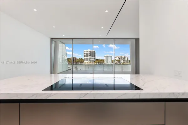 a kitchen with stainless steel appliances kitchen island a large window in it