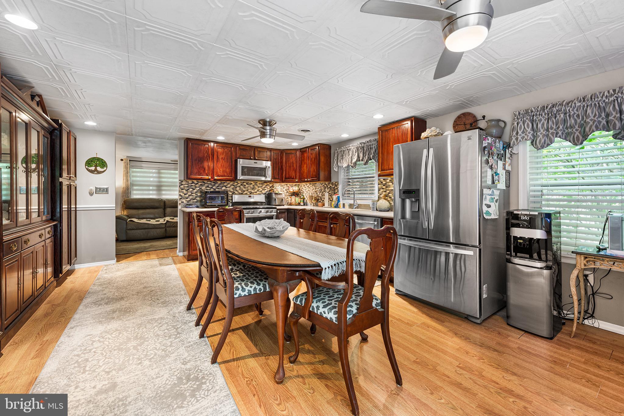 405 East Millstream Road Cream Ridge, NJ 08514 - Photo 13 of 37 a kitchen with stainless steel appliances a refrigerator a stove top oven a sink dishwasher a dining table and chairs with wooden floor