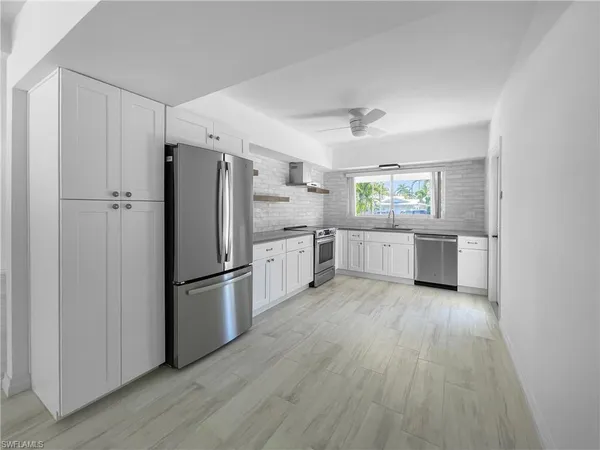 a kitchen with a refrigerator a sink and dishwasher a oven with wooden floor